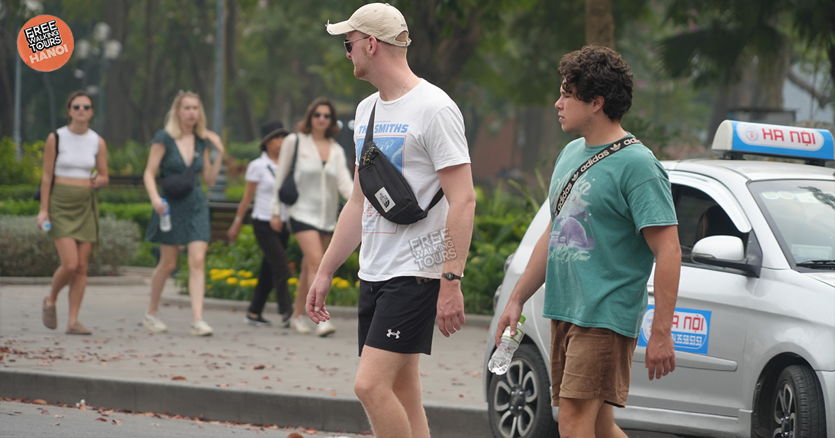 Group of travelers walking in Hanoi’s Old Quarter, led by a local guide